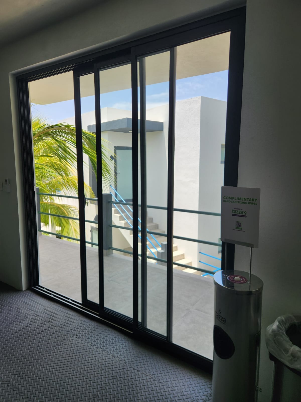 Black aluminium sliding patio door leading onto a balcony with railings in Anguilla