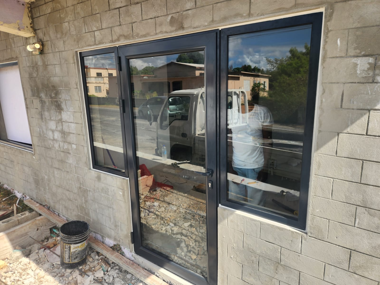 Charcoal aluminium door and fixed window unit installed in a block wall in Anguilla
