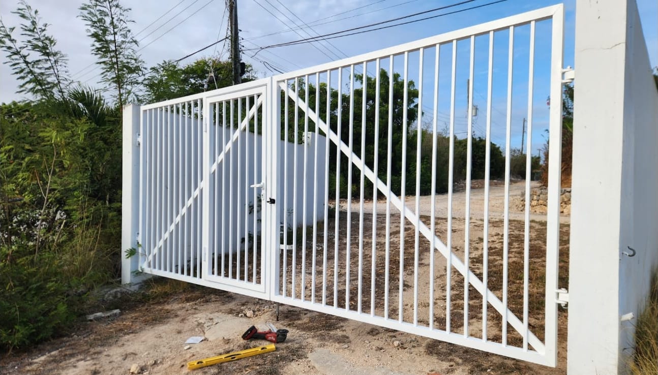 Newly installed white aluminium barrier gate with a diagonal brace on a property in Anguilla