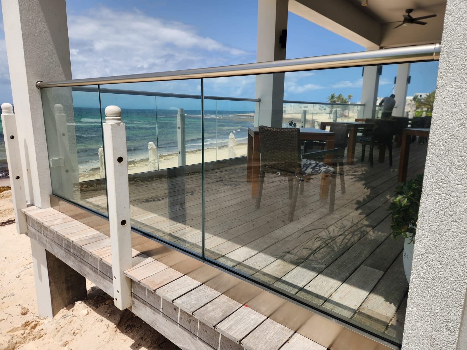 Frameless glass balustrade with a stainless steel top rail on a beachfront deck in Anguilla
