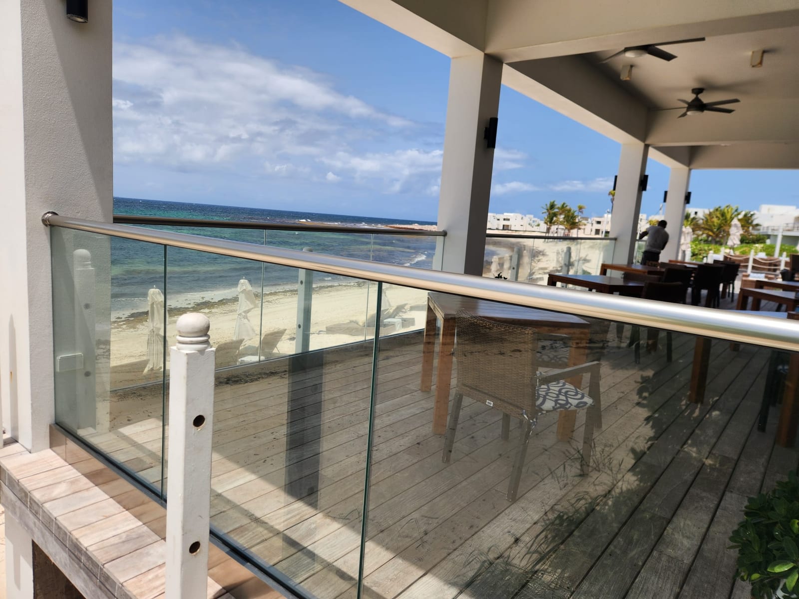 Glass panel balcony railing with a stainless handrail looking out over the sea in Anguilla