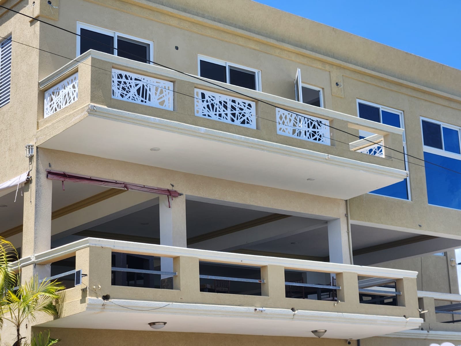 Multi-level commercial balcony railings with white laser-cut aluminium infill panels