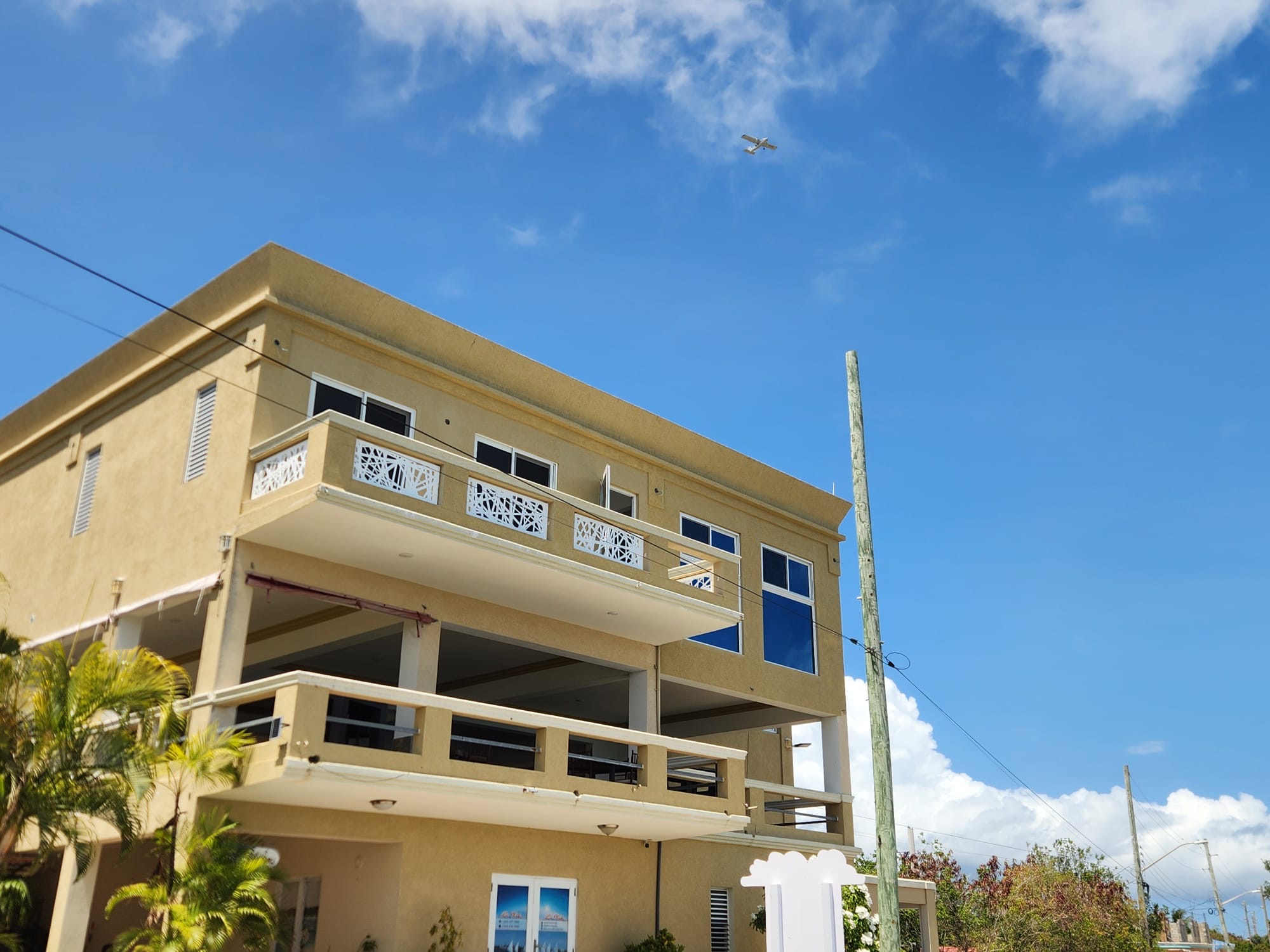 Three-storey apartment building in Anguilla fitted with white laser-cut aluminium balcony railings