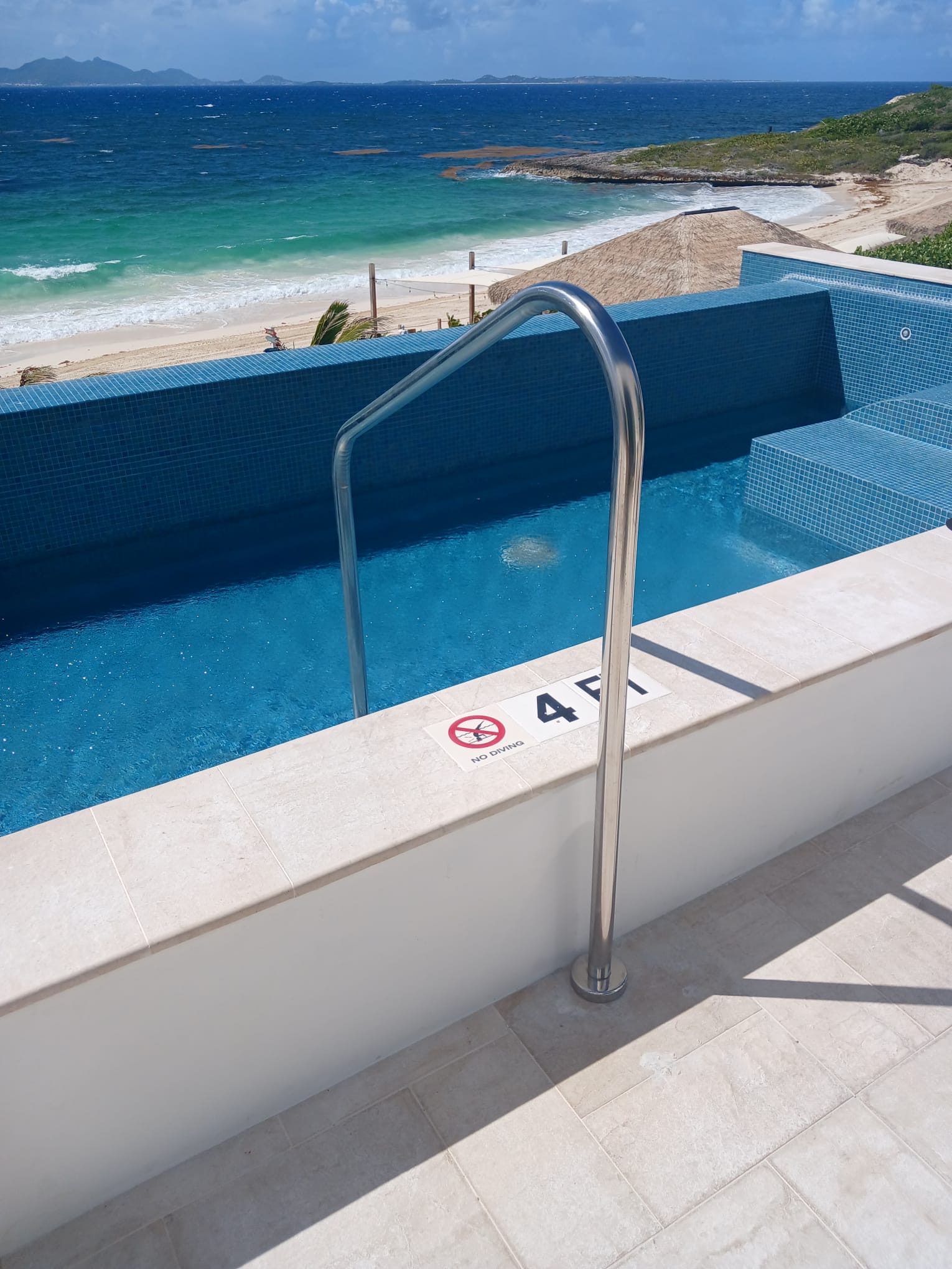 Stainless steel pool handrail at a beachfront villa pool overlooking the sea in Anguilla