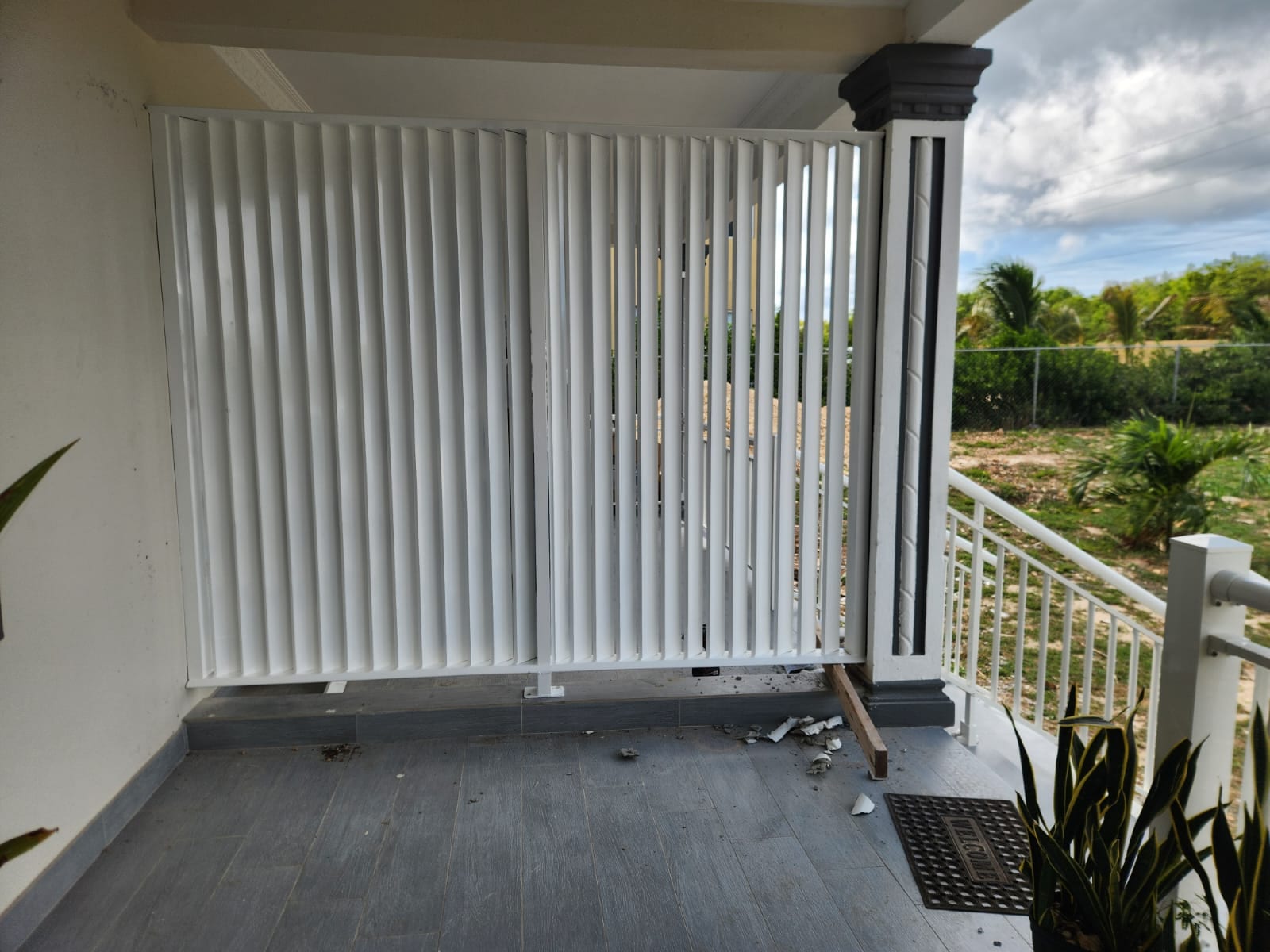 White aluminium louvre screen fitted across a covered porch for shade and privacy in Anguilla