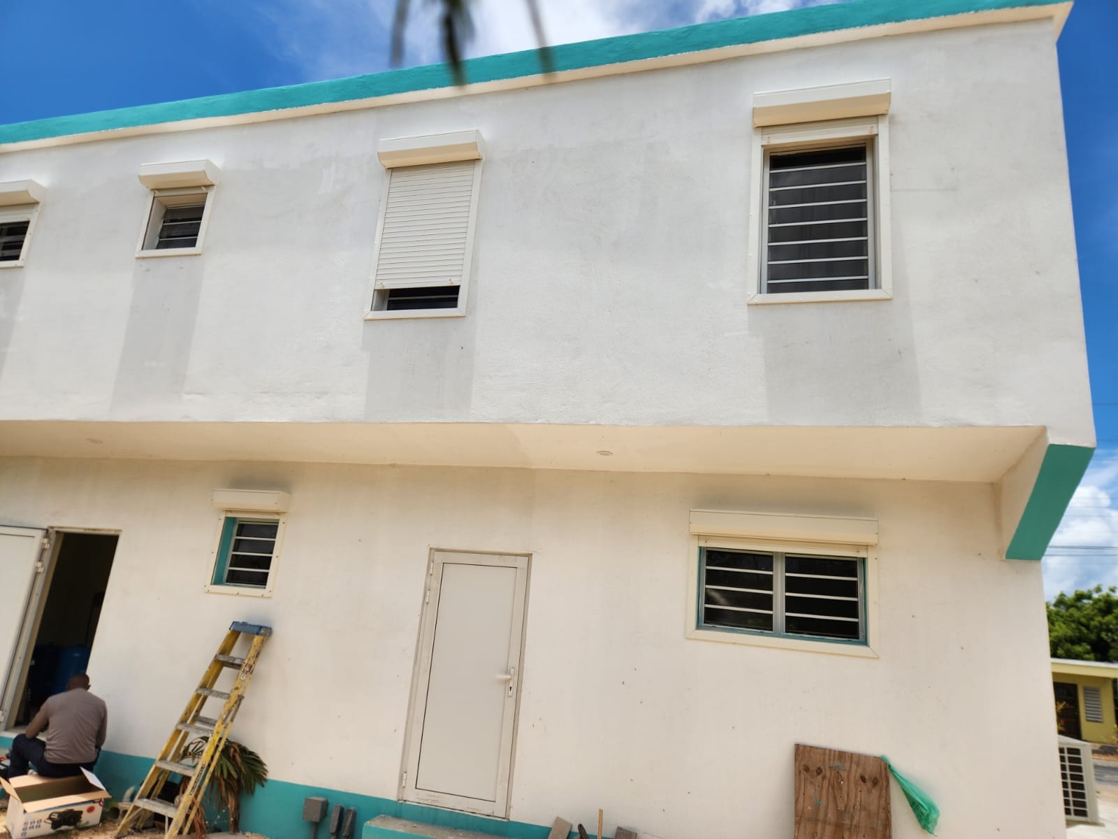 White roller shutters and louvre windows across the facade of an apartment building in Anguilla