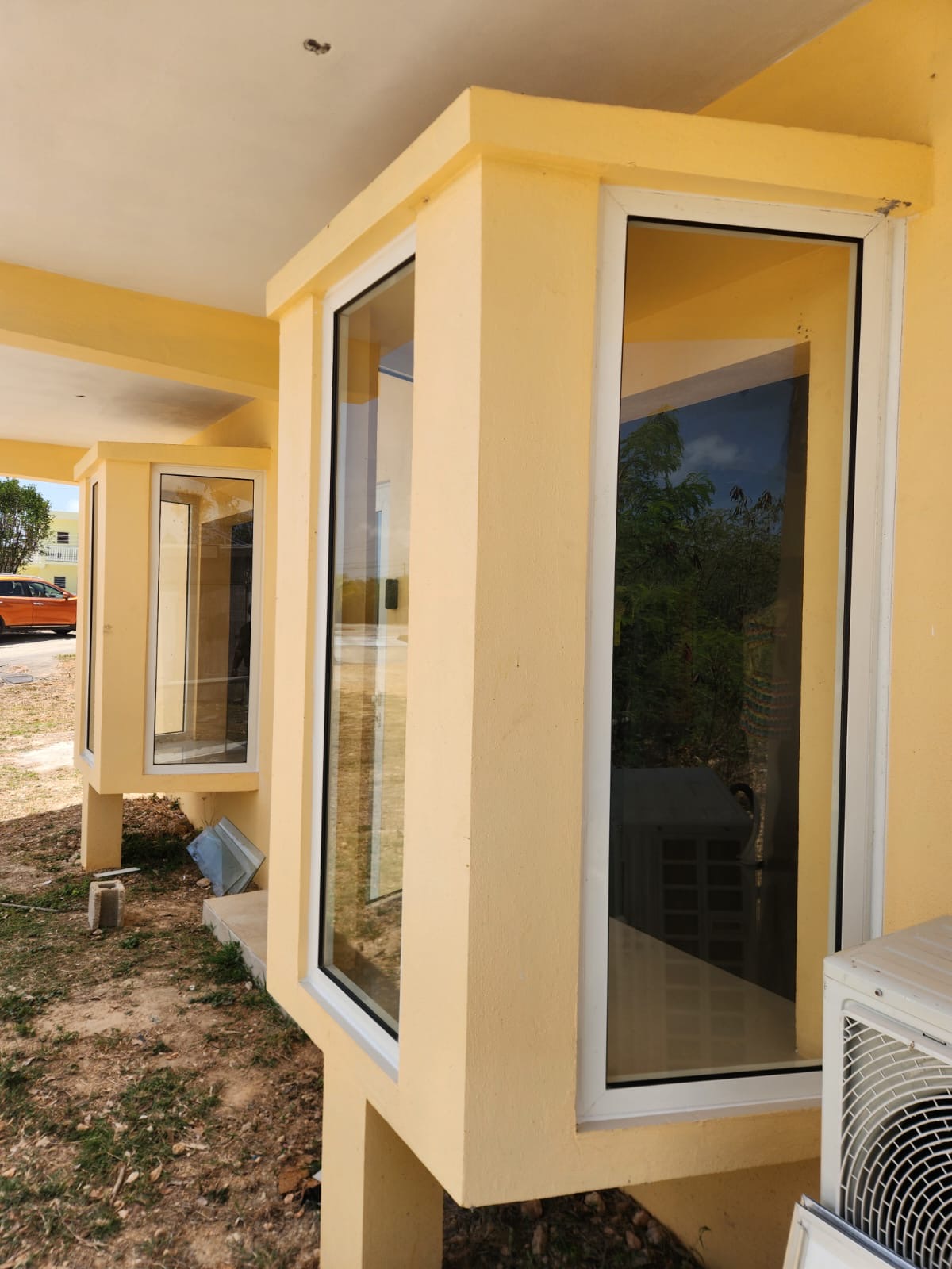 Two aluminium bay window units with white powder-coated frames and tinted glass panels