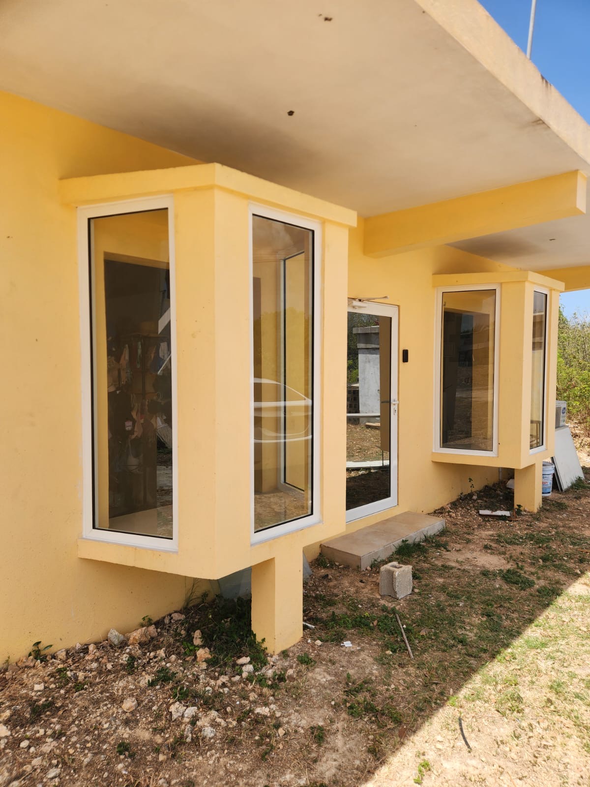 Projecting aluminium bay windows with white frames and tinted glass on a newly built house